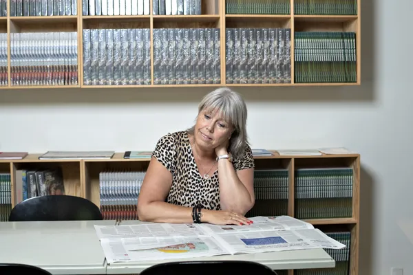 En kvinde laeser og har smerter i nakken.