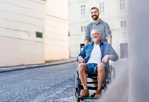 En person i kørestol har en ledsager med sig.