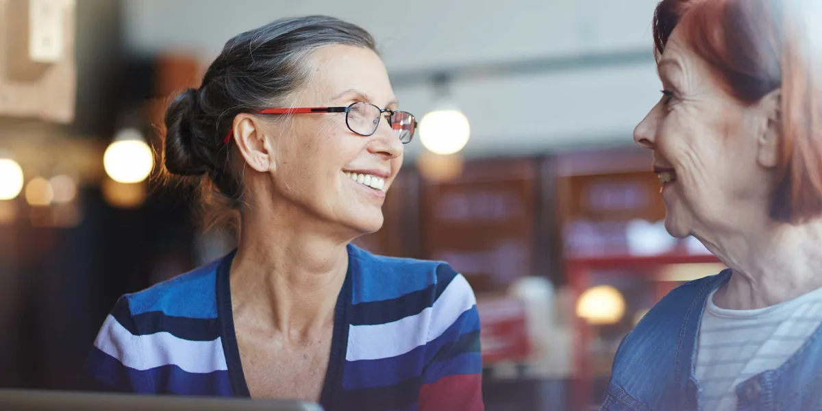Kvinde der smiler til en anden kvinde